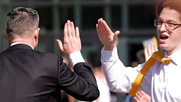 Iowa's new head men's basketball coach Ben McCollum high-fives a crowd member while walking into his introductory press conference Tuesday, March 25, 2025 at Carver-Hawkeye Arena in Iowa City, Iowa.