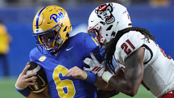 Oct 25, 2025; Pittsburgh, Pennsylvania, USA;  Pittsburgh Panthers quarterback Mason Heintschel (6) carries the ball  against North Carolina State Wolfpack cornerback Jamel Johnson (21) during the fourth quarter at Acrisure Stadium. Mandatory Credit: Charles LeClaire-Imagn Images