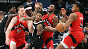 Jan 3, 2024; Memphis, Tennessee, USA; Memphis Grizzlies guard Ja Morant (12) looses control of the ball as Toronto Raptors center Jakob Poeltl (19), guard Immanuel Quickley (5) and forward Scottie Barnes (4) defends during the second half at FedExForum. Mandatory Credit: Petre Thomas-Imagn Images