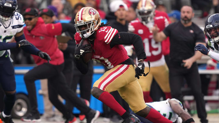 Dec 10, 2023; Santa Clara, California, USA; San Francisco 49ers wide receiver Brandon Aiyuk (11) runs after a catch against Seattle Seahawks linebacker Jordyn Brooks (56) and safety Julian Love (20) during the fourth quarter at Levi's Stadium. Mandatory Credit: Darren Yamashita-USA TODAY Sports