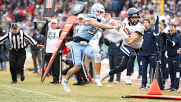 UConn's Joe Fagnano is pushed out of bounds by North Carolina's Michael Short during the third annual Wasabi Fenway Bowl at Fenway Park on Saturday, Dec. 28, 2024.