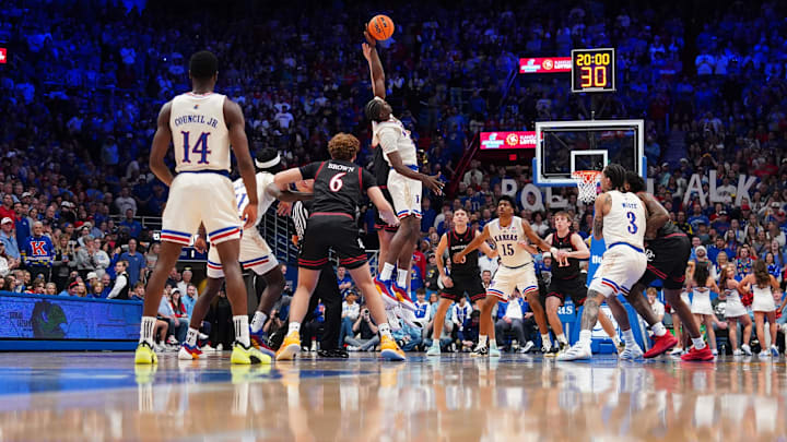 Dec 22, 2025; Lawrence, Kansas, USA; Davidson Wildcats guard Ian Platteeuw (16) and Kansas Jayhawks forward Flory Bidunga (40) fight for the opening jump ball of the game at Allen Fieldhouse. Mandatory Credit: Denny Medley-Imagn Images