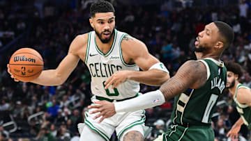 Boston Celtics forward Jayson Tatum (0) drives for the basket against Milwaukee Bucks guard Damian Lillard (0) in the third quarter at Fiserv Forum.