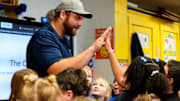 Cincinnati Bengals center Ted Karras (64) high fives a third grader on Tuesday, Nov. 28, 2023, at St. Joseph   s Consolidated School in Hamilton, Ohio. Over a year ago Karras began selling The Cincy Hat, a project that gives 100% of the proceeds from hat sales to The Village of Merici, an Indianapolis-based    living community and services provider for adults with disabilities.   