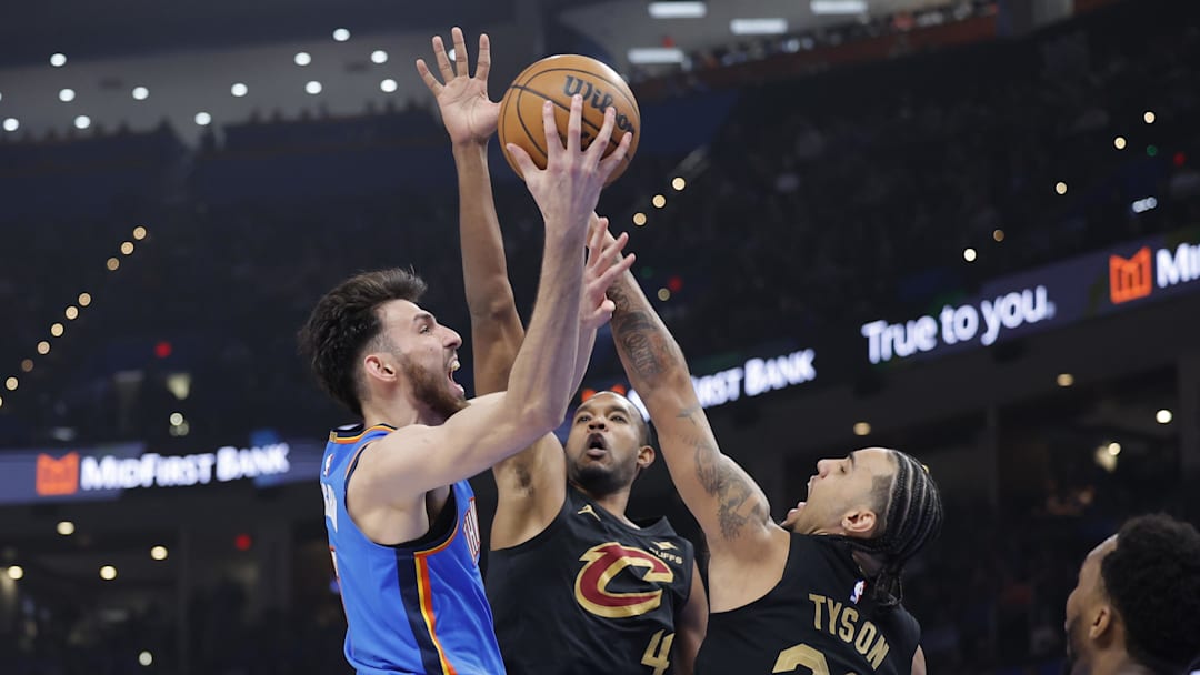 Feb 22, 2026; Oklahoma City, Oklahoma, USA; Oklahoma City Thunder center/forward Chet Holmgren (7) goes up for a basket as Cleveland Cavaliers guard Jaylon Tyson (20) and center Evan Mobley (4) defend during the first half at Paycom Center. Mandatory Credit: Alonzo Adams-Imagn Images