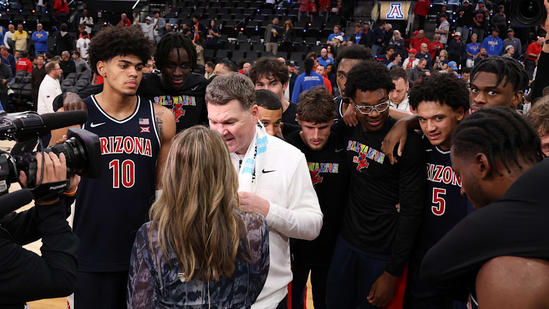 Nov 14, 2025; Inglewood, California, USA;  Arizona Wildcats head coach Tommy Lloyd surrounds by his players as he is taking a post game interview after defeating the UCLA Bruins 69-65 at Intuit Dome. Mandatory Credit: Kiyoshi Mio-Imagn Images