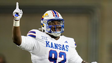 Kansas Jayhawks defensive lineman Tommy Dunn Jr. (92) celebrates after Kansas Jayhawks cornerback Cobee Bryant (2) catches an interception during the game against Cincinnati.