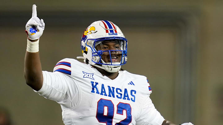 Kansas Jayhawks defensive lineman Tommy Dunn Jr. (92) celebrates after Kansas Jayhawks cornerback Cobee Bryant (2) catches an interception during the game against Cincinnati.