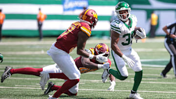 Aug 10, 2024; East Rutherford, New Jersey, USA; New York Jets running back Xazavian Valladay (35) fight for yards as Washington Commanders safety Dominique Hampton (45) and cornerback Nick Whiteside II (37) pursues during the second half at MetLife Stadium. Mandatory Credit: Vincent Carchietta-Imagn Images