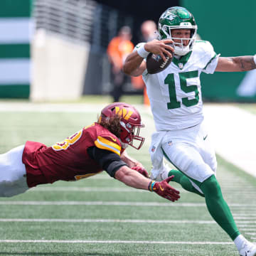 Aug 10, 2024; East Rutherford, New Jersey, USA; New York Jets quarterback Adrian Martinez (15) scrambles for a first down as Washington Commanders safety Ben Nikkel (48) pursues during the second half at MetLife Stadium. Mandatory Credit: Vincent Carchietta-USA TODAY Sports