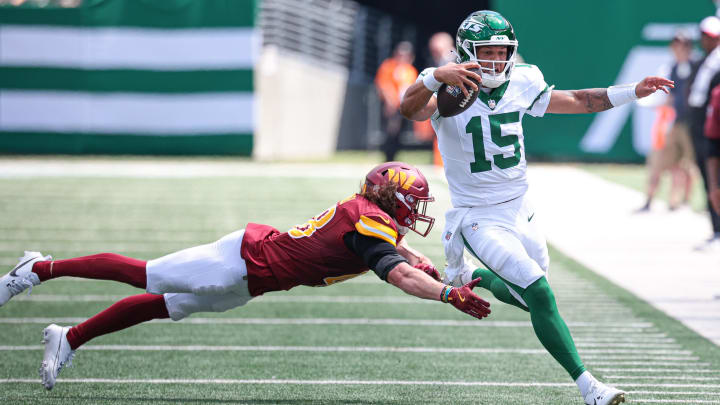 Aug 10, 2024; East Rutherford, New Jersey, USA; New York Jets quarterback Adrian Martinez (15) scrambles for a first down as Washington Commanders safety Ben Nikkel (48) pursues during the second half at MetLife Stadium. Mandatory Credit: Vincent Carchietta-USA TODAY Sports