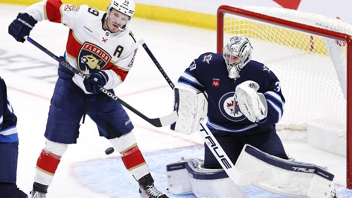Nov 19, 2024; Winnipeg, Manitoba, CAN; Florida Panthers left wing Matthew Tkachuk (19) tries for a tip in on Winnipeg Jets goaltender Connor Hellebuyck (37) in the third period at Canada Life Centre. Mandatory Credit: James Carey Lauder-Imagn Images