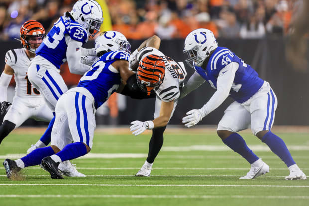 Indianapolis Colts safety Nick Cross and linebacker Zaire Franklin make a tackle in blue jerseys.