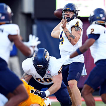 Toledo Rockets quarterback Tucker Gleason (4) throws a pass to wide receiver Junior Vandeross III (2) during the second half against the Wyoming Cowboys in the Arizona Bowl at Arizona Stadium.