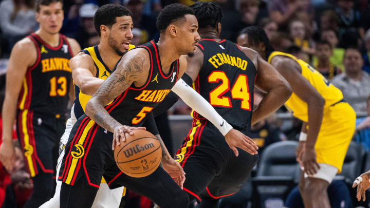 Apr 14, 2024; Indianapolis, Indiana, USA; Atlanta Hawks guard Dejounte Murray (5) dribbles the ball while Indiana Pacers guard Tyrese Haliburton (0) defends in the first half at Gainbridge Fieldhouse.