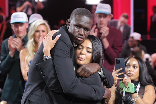 Khaman Maluach embraces a family member after being drafted.