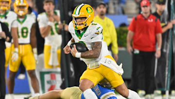 Sep 28, 2024; Pasadena, California, USA; Oregon Ducks quarterback Dillon Gabriel (8) runs past UCLA Bruins linebacker Carson Schwesinger (49) during the during the third quarter at Rose Bowl. Mandatory Credit: Robert Hanashiro-Imagn Images