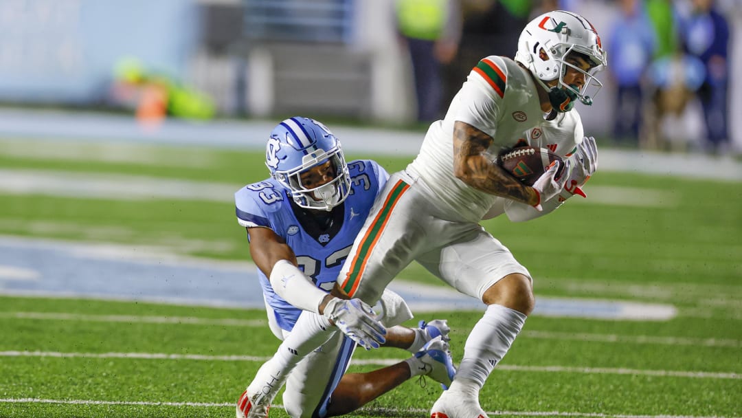 Oct 14, 2023; Chapel Hill, North Carolina, USA; Miami Hurricanes wide receiver Xavier Restrepo (7) escapes from North Carolina Tar Heels linebacker Cedric Gray (33) after a catch in the second half at Kenan Memorial Stadium. Mandatory Credit: Nell Redmond-USA TODAY Sports