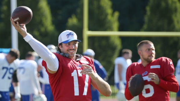 Bills quarterbacks Josh Allen and Shane Buechele warm up on the sideline.