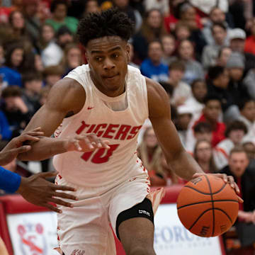 Fishers Tigers guard Jalen Haralson (10) dribbles towards the hoop.