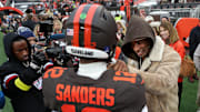 NFL legend Deion Sanders, right, gives his son Shedeur Sanders a pep talk before an NFL football game at Huntington Bank Field, Dec. 7, 2025, in Cleveland, Ohio.