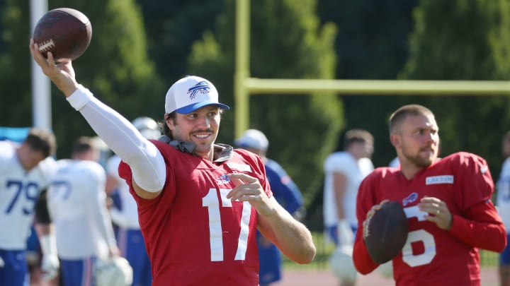 Bills quarterbacks Josh Allen and Shane Buechele warm up on the sideline.