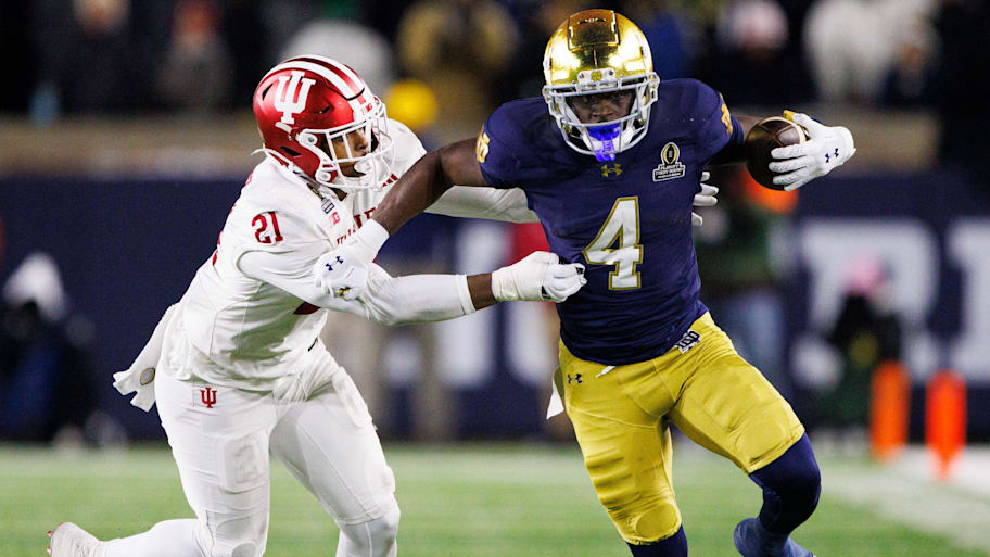 Notre Dame running back Jeremiyah Love (4) runs the ball past Indiana linebacker Rolijah Hardy during a CFP game.