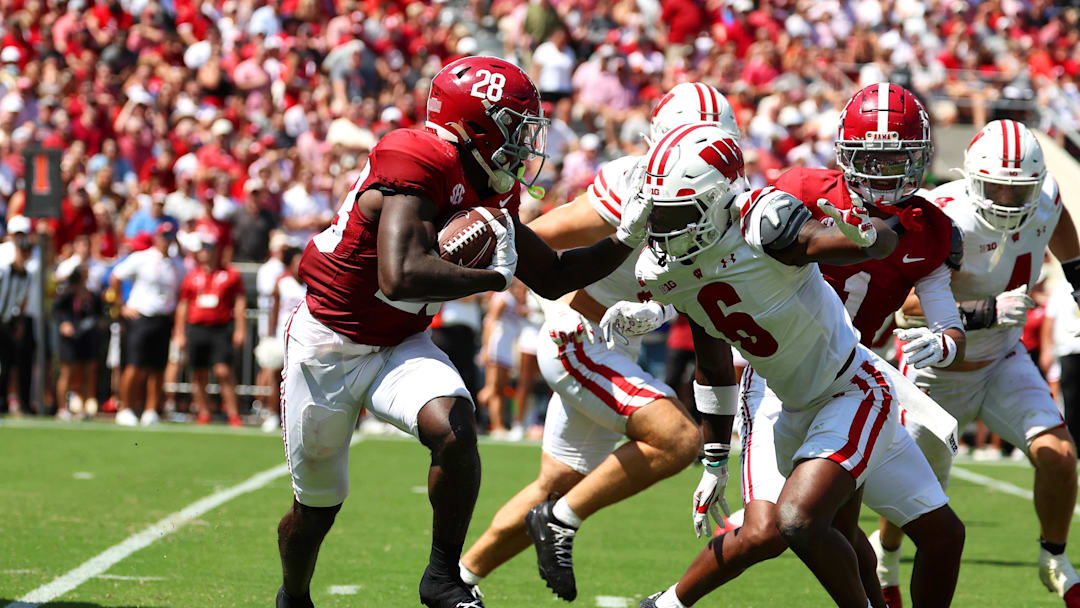 Sep 13, 2025; Tuscaloosa, Alabama, USA; Alabama Crimson Tide running back Kevin Riley (28) avoids a tackle by Wisconsin Badgers cornerback Omillio Agard (6) during the second quarter at Saban Field at Bryant-Denny Stadium. Mandatory Credit: David Leong-Imagn Images