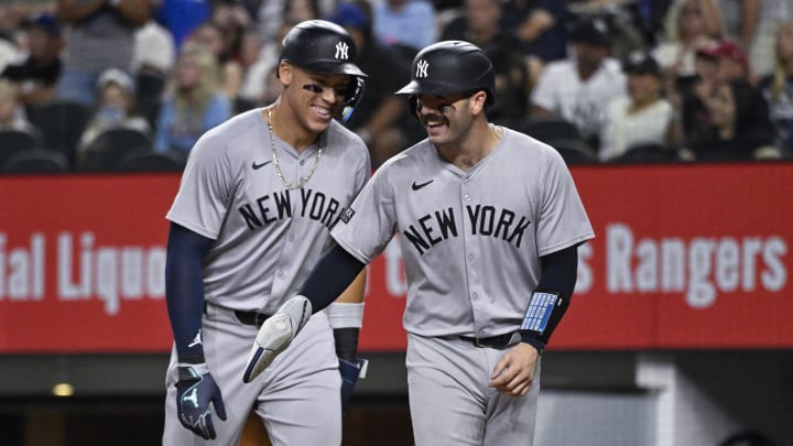 Sep 2, 2024; Arlington, Texas, USA; New York Yankees catcher Austin Wells (right) and center fielder Aaron Judge (left) laugh at home plate as they both score on a ground rule double hit by first baseman Anthony Rizzo (not pictured) during the sixth inning at Globe Life Field. Mandatory Credit: Jerome Miron-USA TODAY Sports