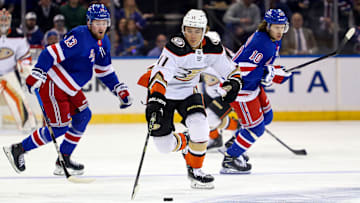Oct 17, 2022; New York, New York, USA; Anaheim Ducks center Trevor Zegras (11) reaches for the puck in front of New York Rangers left wing Alexis Lafreniere (13) and New York Rangers left wing Artemi Panarin (10) during the first period at Madison Square Garden. Mandatory Credit: Danny Wild-Imagn Images