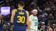 Feb 23, 2024; San Francisco, California, USA; Charlotte Hornets guard Seth Curry (right) talks with Golden State Warriors guard Stephen Curry (left) during the fourth quarter at Chase Center. Mandatory Credit: Darren Yamashita-Imagn Images
