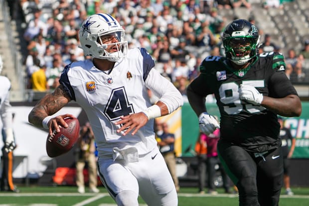 Dallas Cowboys quarterback Dak Prescott looks to pass downfield as New York Jets defensive tackle Quinnen Williams 
