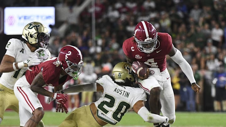 Sep 7, 2024; Tuscaloosa, Alabama, USA;  Alabama Crimson Tide quarterback Jalen Milroe (4) tries to leap through a tackle by South Florida Bulls cornerback Brent Austin (20) at Bryant-Denny Stadium. Alabama won 42-16. Mandatory Credit: Gary Cosby Jr.-Imagn Images
