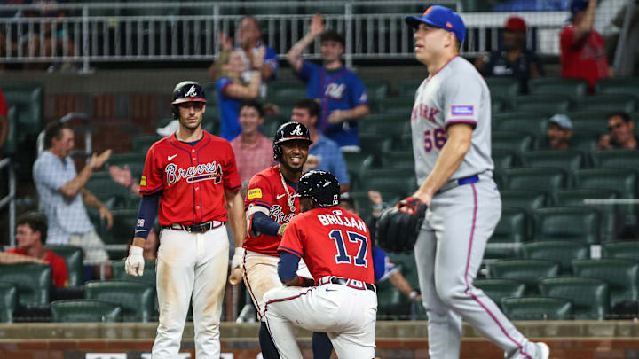 Aug 22, 2025; Cumberland, Georgia, USA; Atlanta Braves shortstop Nick Allen (2) helps up Atlanta third base Vidal Brujan (17) after scoring against the New York Mets during the ninth inning at Truist Park. Mandatory Credit: Jordan Godfree-Imagn Images