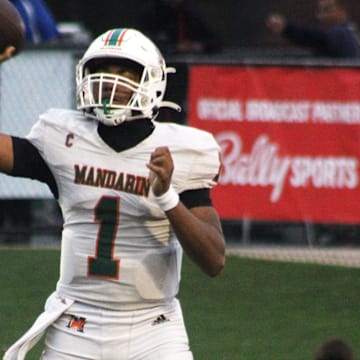 Mandarin quarterback Tramell Jones (1) prepares to toss a short pass over Miami Columbus pass rusher Willis McGahee IV (17) during the FHSAA Class 4M high school football championship game on December 8, 2023. [Clayton Freeman/Florida Times-Union]