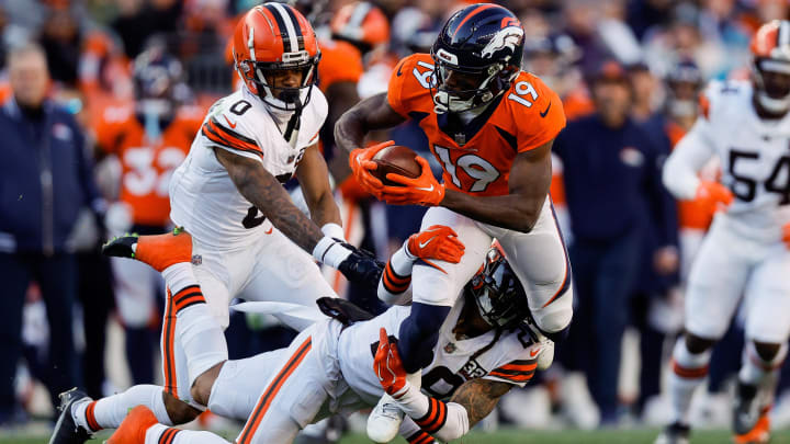 Nov 26, 2023; Denver, Colorado, USA; Denver Broncos wide receiver Marvin Mims Jr. (19) is tackled by Cleveland Browns cornerback Mike Ford Jr. (28) as cornerback Greg Newsome II (0) defends in the second quarter at Empower Field at Mile High. 