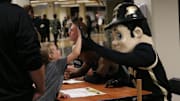 Purdue Boilermaker mascot guard Purdue Pete gives a high-five to a young fan 