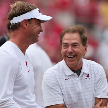 Oct 2, 2021; Tuscaloosa, Alabama, USA;  Mississippi Rebels head coach Lane Kiffin talks with Alabama Crimson Tide head coach Nick Saban before the start of an NCAA college football game at Bryant-Denny Stadium. Mandatory Credit: Butch Dill-Imagn Images