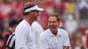 Oct 2, 2021; Tuscaloosa, Alabama, USA;  Mississippi Rebels head coach Lane Kiffin talks with Alabama Crimson Tide head coach Nick Saban before the start of an NCAA college football game at Bryant-Denny Stadium. Mandatory Credit: Butch Dill-Imagn Images