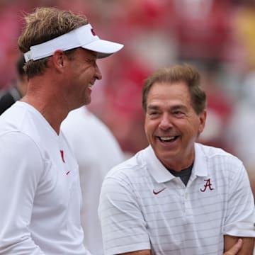 Oct 2, 2021; Tuscaloosa, Alabama, USA;  Mississippi Rebels head coach Lane Kiffin talks with Alabama Crimson Tide head coach Nick Saban before the start of an NCAA college football game at Bryant-Denny Stadium. Mandatory Credit: Butch Dill-Imagn Images