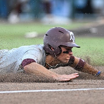 Jun 24, 2024; Omaha, NE, USA;  Texas A&M Aggies second baseman Kaeden Kent (3) slides into third base against the Tennessee Volunteers during the seventh inning at Charles Schwab Field Omaha. Mandatory Credit: Steven Branscombe-Imagn Images