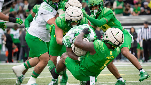 Oregon Green Team defensive end Jordan Burch brings down White Team running back Jordan James during the Oregon Ducks’ Spring