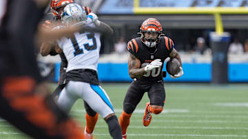Sep 29, 2024; Charlotte, North Carolina, USA; Cincinnati Bengals running back Chase Brown (30) runs around the block on Carolina Panthers cornerback Troy Hill (13) during the third quarter at Bank of America Stadium. Mandatory Credit: Jim Dedmon-Imagn Images