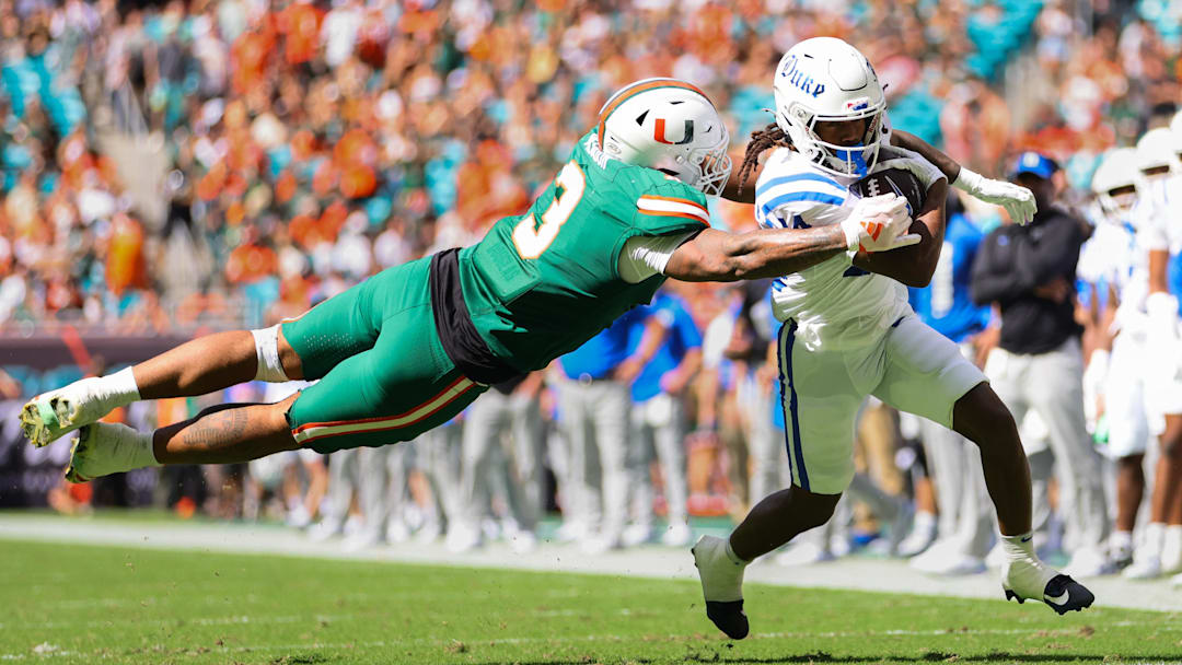 Nov 2, 2024; Miami Gardens, Florida, USA; Duke Blue Devils wide receiver Que'Sean Brown (14) runs with the football past Miami Hurricanes defensive lineman Akheem Mesidor (3) during the second quarter at Hard Rock Stadium. Mandatory Credit: Sam Navarro-Imagn Images