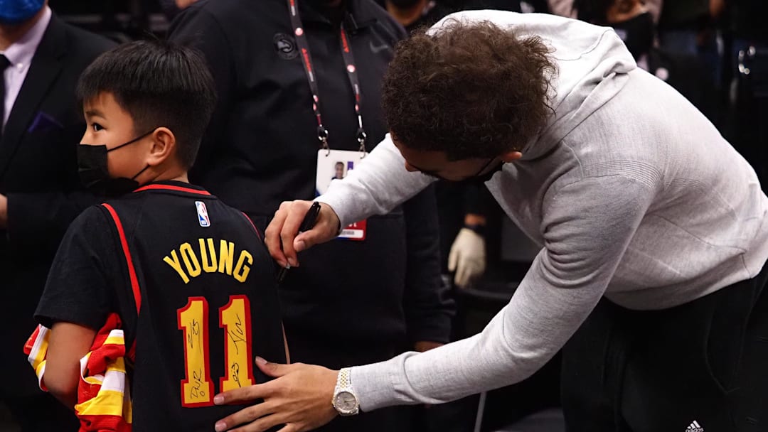 Jan 5, 2022; Sacramento, California, USA; Atlanta Hawks guard Trae Young (11) signs the jersey of a young fan after the game against the Sacramento Kings at Golden 1 Center. Mandatory Credit: Kelley L Cox-Imagn Images