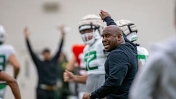 Oregon running backs coach Carlos Locklyn calls to players Tuesday, April 12, 2022, at practice with
