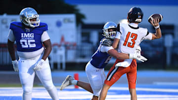IMG Academy defensive lineman Jake Kruel (#88) wraps up Cocoa High quarterback Brady Hart (#13). Hart was called for a penalty for illegal forward pass on the play when he caught the ball tipped by IMG lineman Cameron McHaney (#95) and tried to pass it again. The IMG Academy National squad hosted the Cocoa High School Tigers Friday, Sept. 6, 2024 in Bradenton.