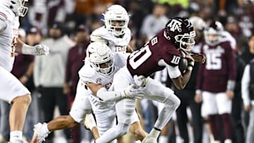 Nov 30, 2024; College Station, Texas, USA; Texas A&M Aggies quarterback Marcel Reed (10) is tackled by Texas Longhorns defensive back Michael Taaffe (16) during the first quarter. The Longhorns defeated the Aggies 17-7 at Kyle Field. Mandatory Credit: Maria Lysaker-Imagn Images  