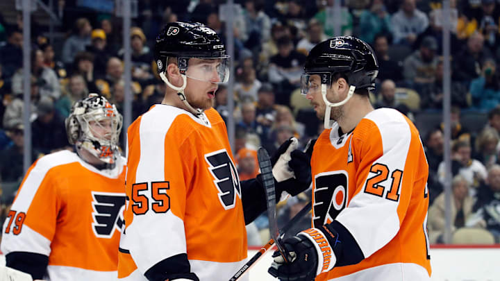 Mar 11, 2023; Pittsburgh, Pennsylvania, USA;  Philadelphia Flyers defenseman Rasmus Ristolainen (55) and center Scott Laughton (21) talk in front of Flyers goaltender Carter Hart (79) against the Pittsburgh Penguins during the second period at PPG Paints Arena.