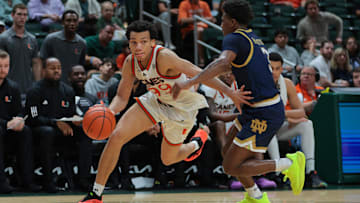 Feb 1, 2025; Coral Gables, Florida, USA; Miami Hurricanes guard Divine Ugochukwu (99) drives to the basket past Notre Dame Fighting Irish guard Markus Burton (3) during the second half at Watsco Center. Mandatory Credit: Sam Navarro-Imagn Images